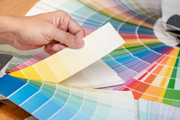 istock Designer hand choosing color swatch samples catalog or rainbow colour palette guide for selection coloring on architecture and interior design work. 1768087811