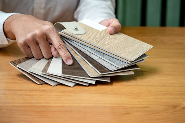 istock Designer hand choosing and pointing at wood texture laminate material samples or wooden palette catalog guide for interior architecture and furniture design work. 1768093065