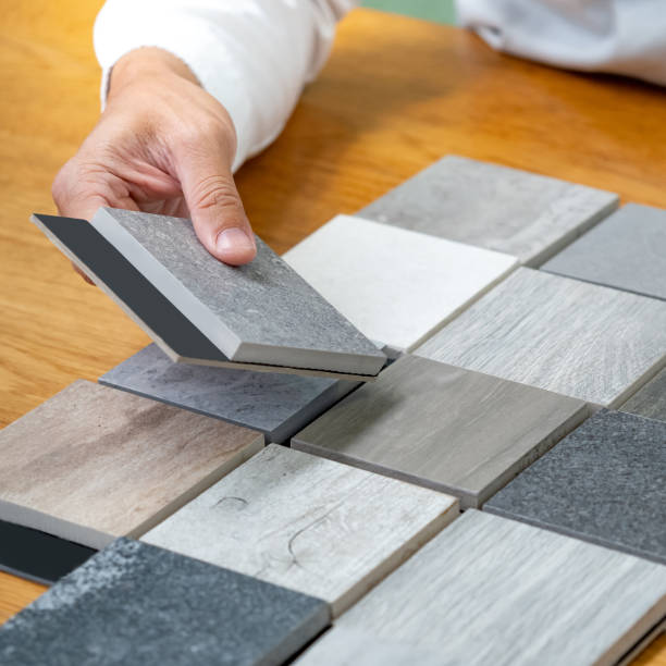 istock Architect hand choosing sample of stone material or tile texture collection on the table in studio. Designer working for interior architecture and furniture design project. 1768093972