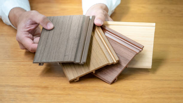 istock Designer hand choosing wood texture laminate material samples for wall and floor skirting design. Wooden piece catalog guide for interior architecture detail work. 1768093973