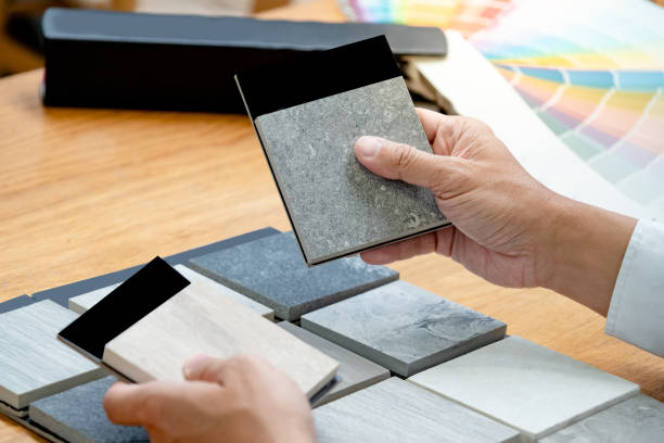 istock Architect hand choosing sample of stone material or tile texture collection on the table in studio. Designer working for interior architecture and furniture design project. 1768093975