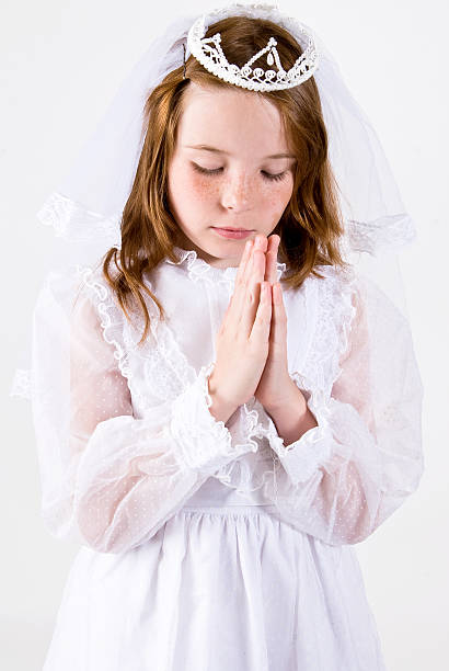 Young girl Praying in First Communion Attire stock photo