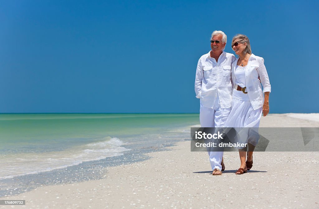 Feliz pareja Senior caminando por una playa Tropical - Foto de stock de Pareja mayor libre de derechos