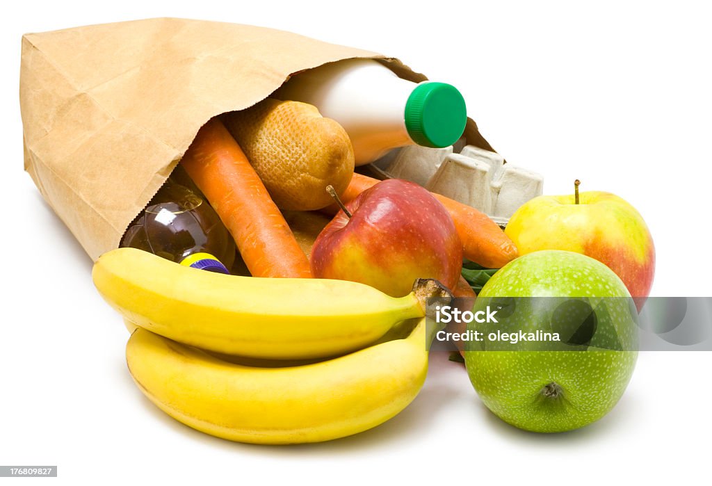 Paper bag on its side with fruit and vegetables spilling out One bag with food isolated  on white background. Milk Stock Photo