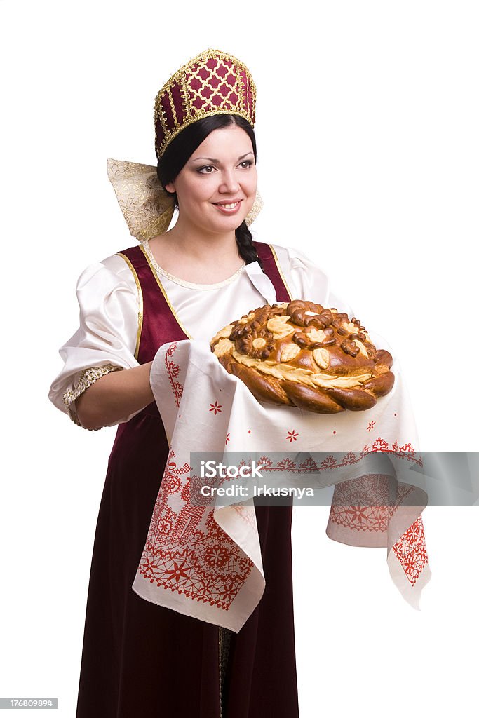 Bread-and-salt welcome Bread-and-salt welcome. A traditional ritual of offering bread and salt to a welcome guest. Girl standing in Russian traditional costume. Woman is wearing sarafan and kokoshnik. 19th Century Stock Photo