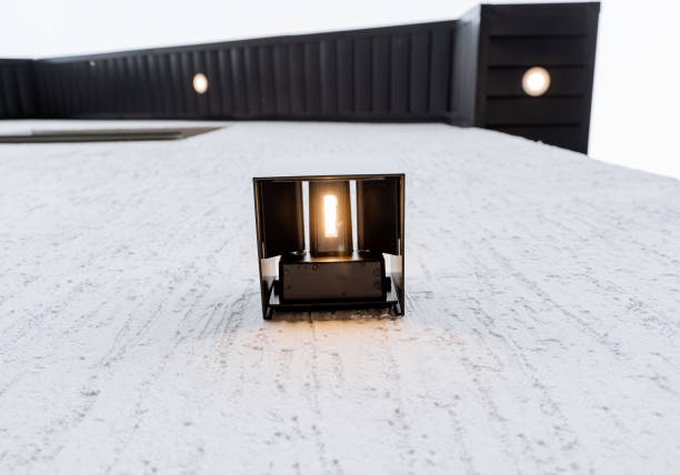 éclairer la maison avec un éclairage ponctuel, une lampe led accrochée au mur du bâtiment éclairant la façade la nuit. veilleuse halogène vue de dessous, macro électrocution - mountable photos et images de collection