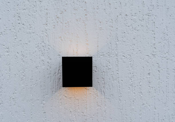 une lampe halogène de forme carrée est accrochée au mur de la maison, éclairage led de la façade du bâtiment, éclairage public d’un immeuble résidentiel, lumière jaune de la lampe. - mountable photos et images de collection