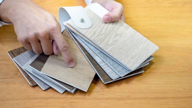 istock Designer hand choosing and pointing at wood texture laminate material samples or wooden palette catalog guide for interior architecture and furniture design work. 1768103154