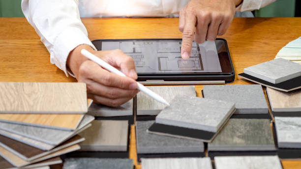 Architect hand choosing and picking stone and wood material samples while drawing on a digital tablet on the table in studio. Designer working for interior architecture and furniture design project arquitecto eligiendo y recogiendo a mano muestras de materiales de piedra y madera mientras dibuja en una tableta digital sobre la mesa en el estudio. diseñadora que trabaja para proyectos de arquitectura de interiores y diseño de mobiliario