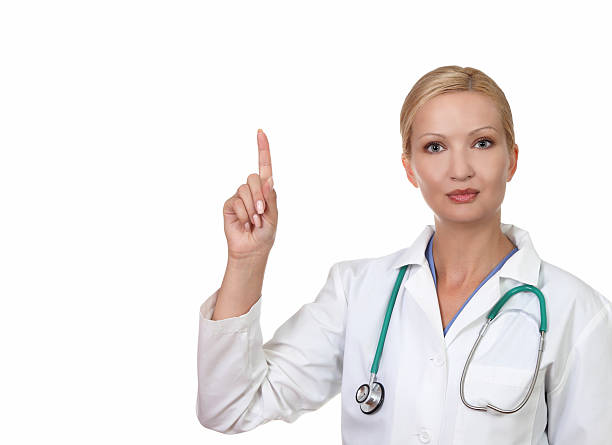 Closeup of a young  female doctor pointing  finger upwards stock photo