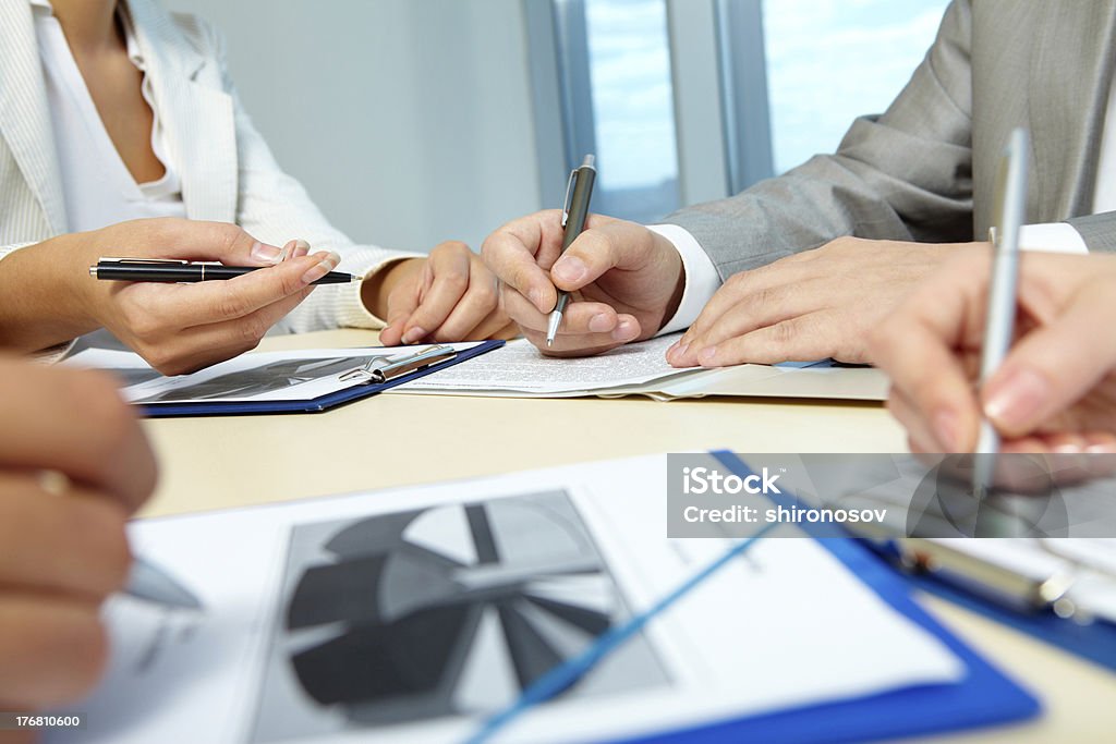 Sharing ideas Image of business people hands working with papers at meeting Business Stock Photo