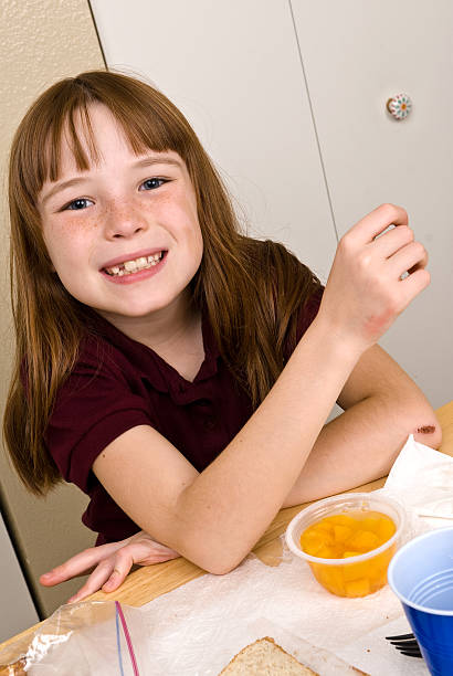 Young school girl eating lunch stock photo