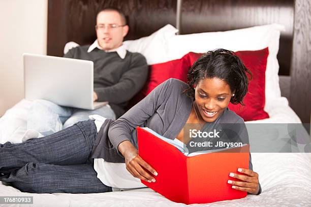 Interracial くつろぐカップルのご予約コンピュータで - 20代のストックフォトや画像を多数ご用意 - 20代, 2人, くつろぐ