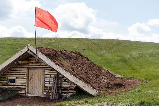 The flag of the Red Army, a military structure, an underground dugout, a command post of the Russian military forces, a dugout against airstrikes, wartime, a wooden structure. High quality photo