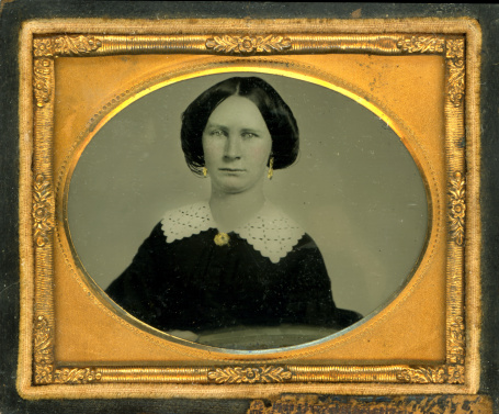 Antique very early Daguerreotype photograph of a beautiful woman. Image has some grunge and dust due to being over 150 years old.  The image is housed in a beautiful gold frame typical of the Victorian Era. This image was taken in the 1840s and is a great example of the popular fashion and hairstyle of the time. This is an extremely early photograph since photography had only been invented a few years prior in 1939 by Louis Daguerre. Notice the gold earrings and broach which people had painted on after the photo was taken if they couldn't afford to wear real jewelry. Download available in Super High Resolution XXXL.