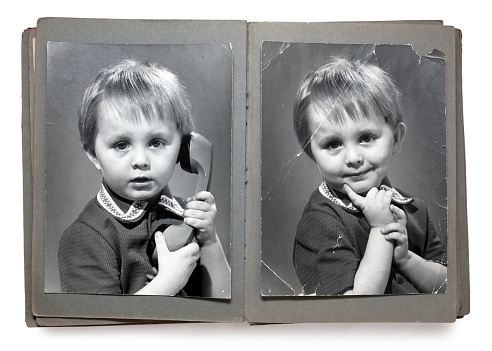 Old album with the children's shabby photos (isolated)