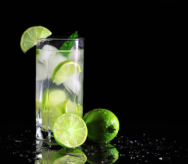 Mojito cocktail with fresh limes Mojito cocktail with fresh limes on a black background mojito stock pictures, royalty-free photos & images