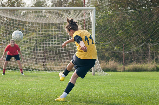 ragazze che giocano a calcio - goal kick foto e immagini stock