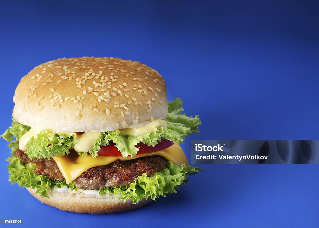 Hamburguesa con queso en un fondo azul - Foto de stock de Fondo con color libre de derechos