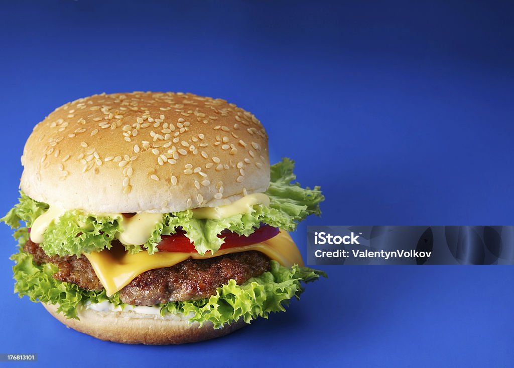 Cheeseburger sur fond bleu - Photo de Burger libre de droits