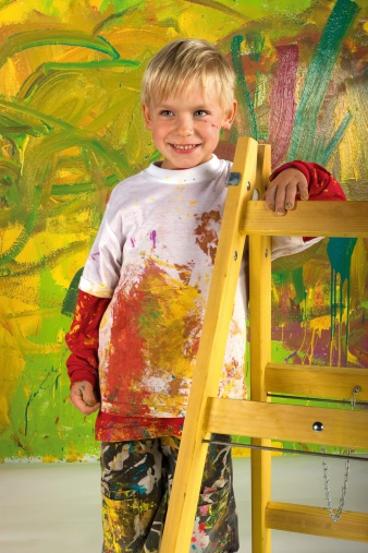 Little boy on ladder in front painted wall