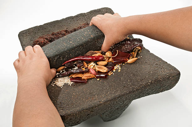 Grinding ingredients to prepare the traditional mexican “mole”