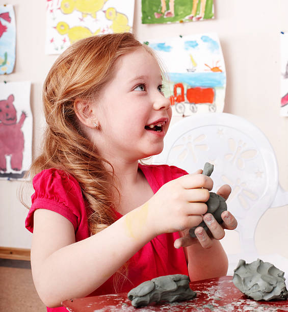 Child  mould from clay in play room. stock photo