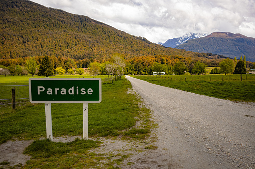 Paradise, New Zealand, road sign next to a dirt road. North of Glenorchy