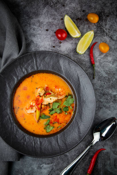 istock spicy tom yum in a black plate with greens, top view 1768140095