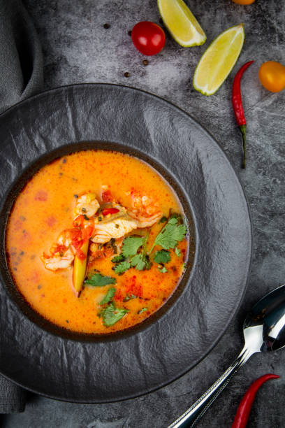 istock spicy tom yum in a black plate with greens, top view 1768140634