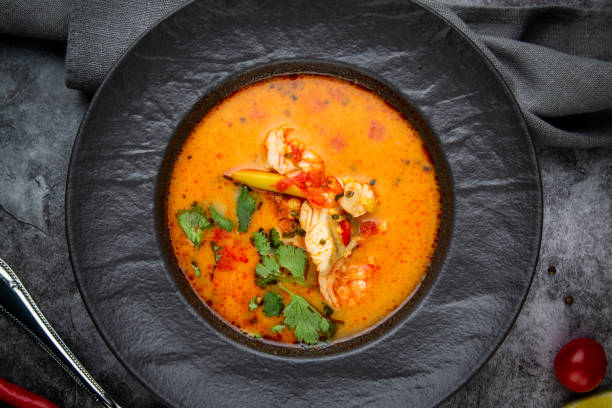 istock spicy tom yum in a black plate with greens, top view 1768141672