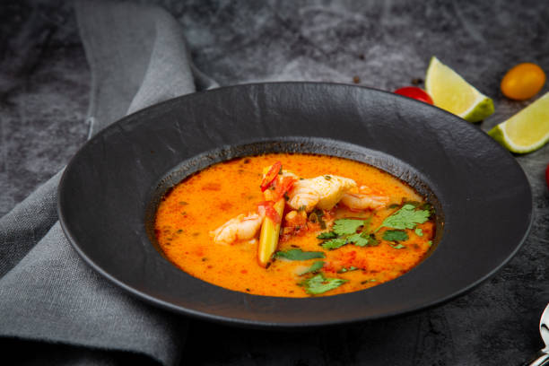 istock spicy tom yum in a black plate with greens, side view 1768142229