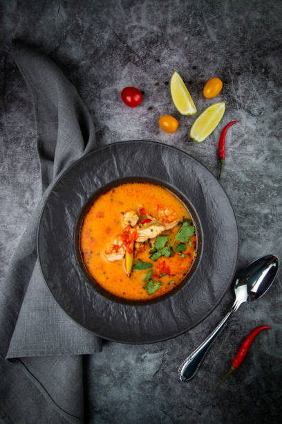 istock spicy tom yum in a black plate with greens, top view 1768144931
