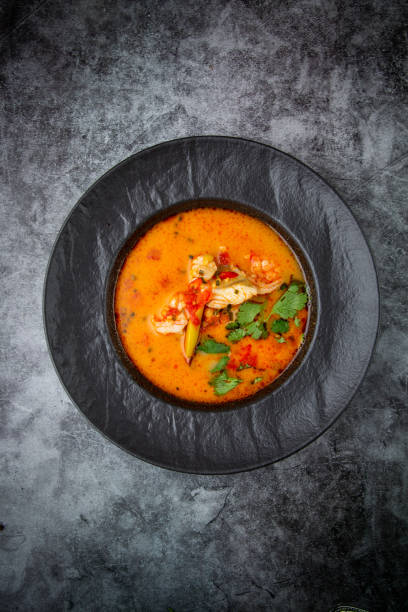 istock spicy tom yum in a black plate with greens, top view 1768146459