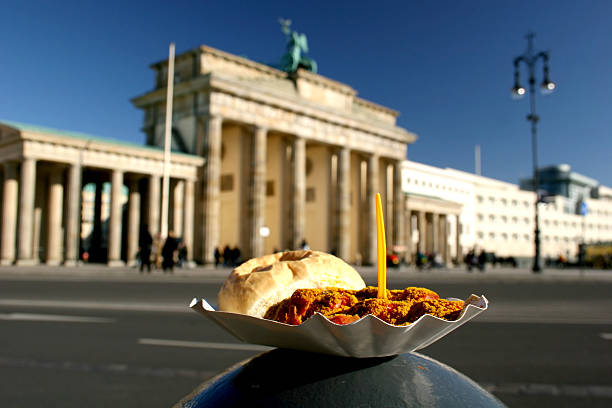 Currywurst and Brandenburg Gate Berlin delicacy Currywurst in front of the landmark Brandenburg Gate, Germany german food photos stock pictures, royalty-free photos & images