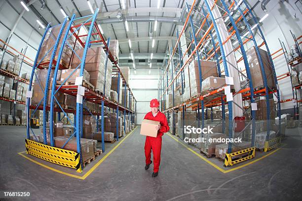 Trabajador Con Caja En El Almacén Foto de stock y más banco de imágenes de Fábrica - Fábrica, Casco - Herramientas profesionales, Casco de trabajo