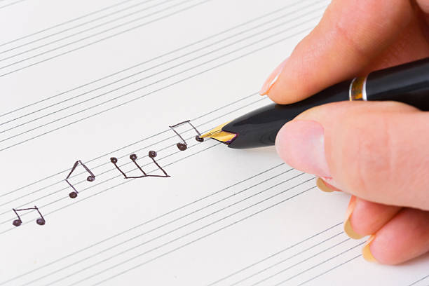 istock Hand with pen and music sheet 176815940