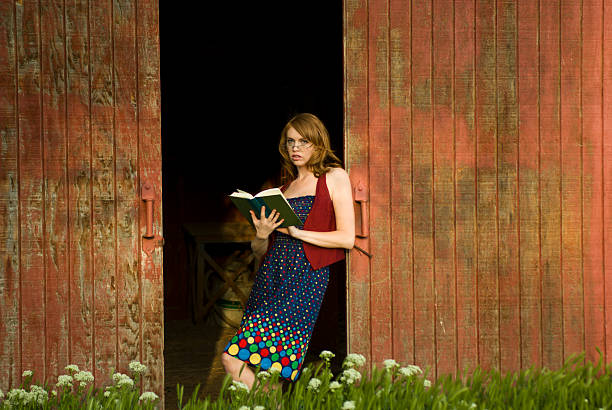 Girl Reading in Barn Door stock photo