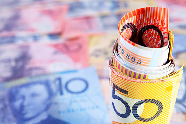 istock Australian currency rolled up on a currency background 176816093