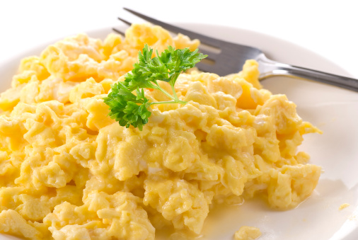 Scrambled eggs with a parsley branch.