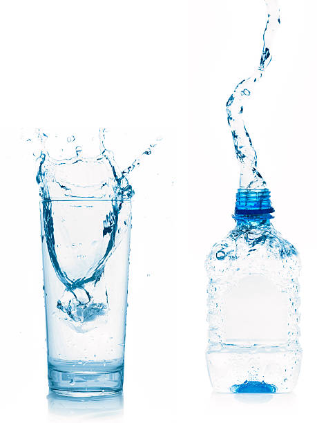 ガラスのボトル入りウォーター、白で分離 - overflowing water glass bottle ストックフォトと画像