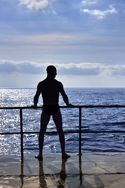 istock Silhouette of young man standing at the seaside 176822049