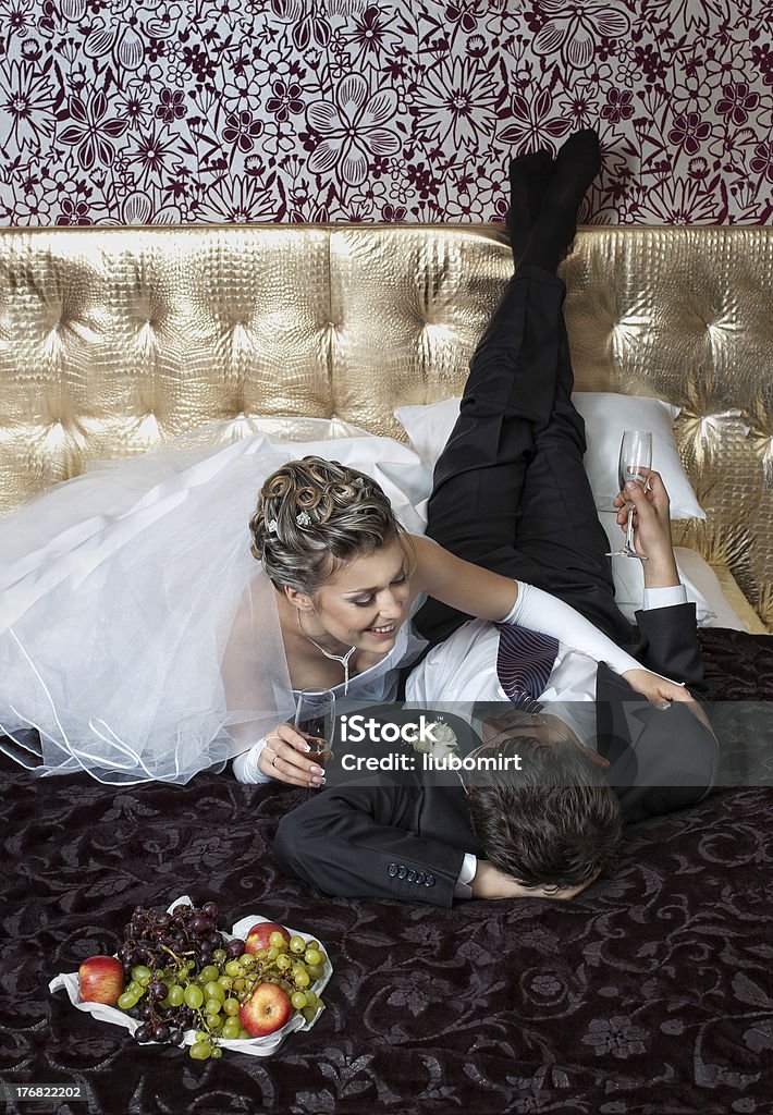 Braut und Bräutigam im luxuriösen Schlafzimmer liegen - Lizenzfrei Alkoholisches Getränk Stock-Foto