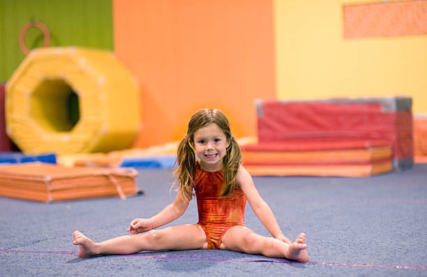 kleine turnerin, die einen mühelos split - gymnastikanzug stock-fotos und bilder