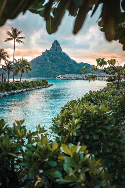 Beautiful Sunset in Bora Bora with a mountain view Majestic view of a Bora Bora sunset with a mountain silhouette in the background bora bora mountain stock pictures, royalty-free photos & images