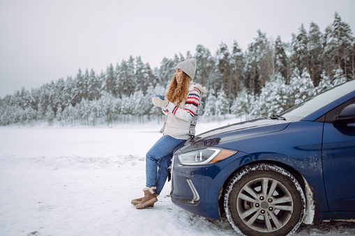 A red car has slid on the icy road and his into the freeway medium. This has created a traffic jam for the other cars.