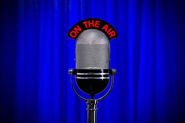 istock Retro microphone with spotlight on blue curtain 176824211