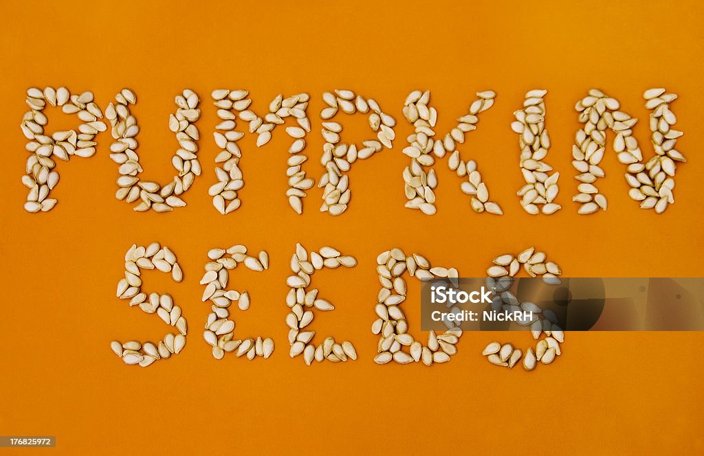 Pumpkin Seeds Pumpkin seeds against an orange background Color Image Stock Photo