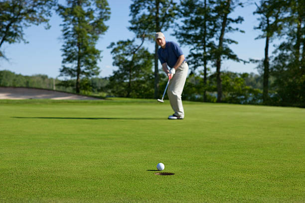 Professional golfer demonstrates focus and skill at a golf resort, ready for an intense game. The sportsman is captured mid-swing with a golf club.