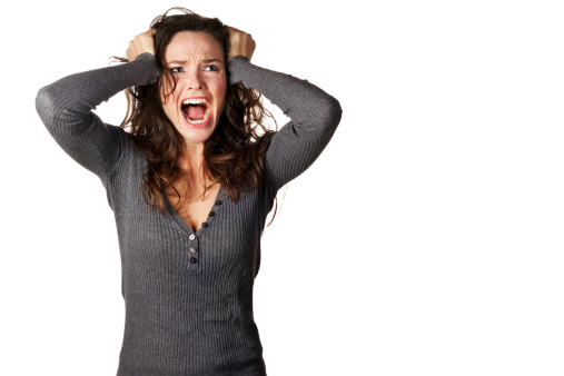 A frustrated and angry woman is screaming out loud and pulling her hair.For more images with realistic expressions click on the lightbox below out